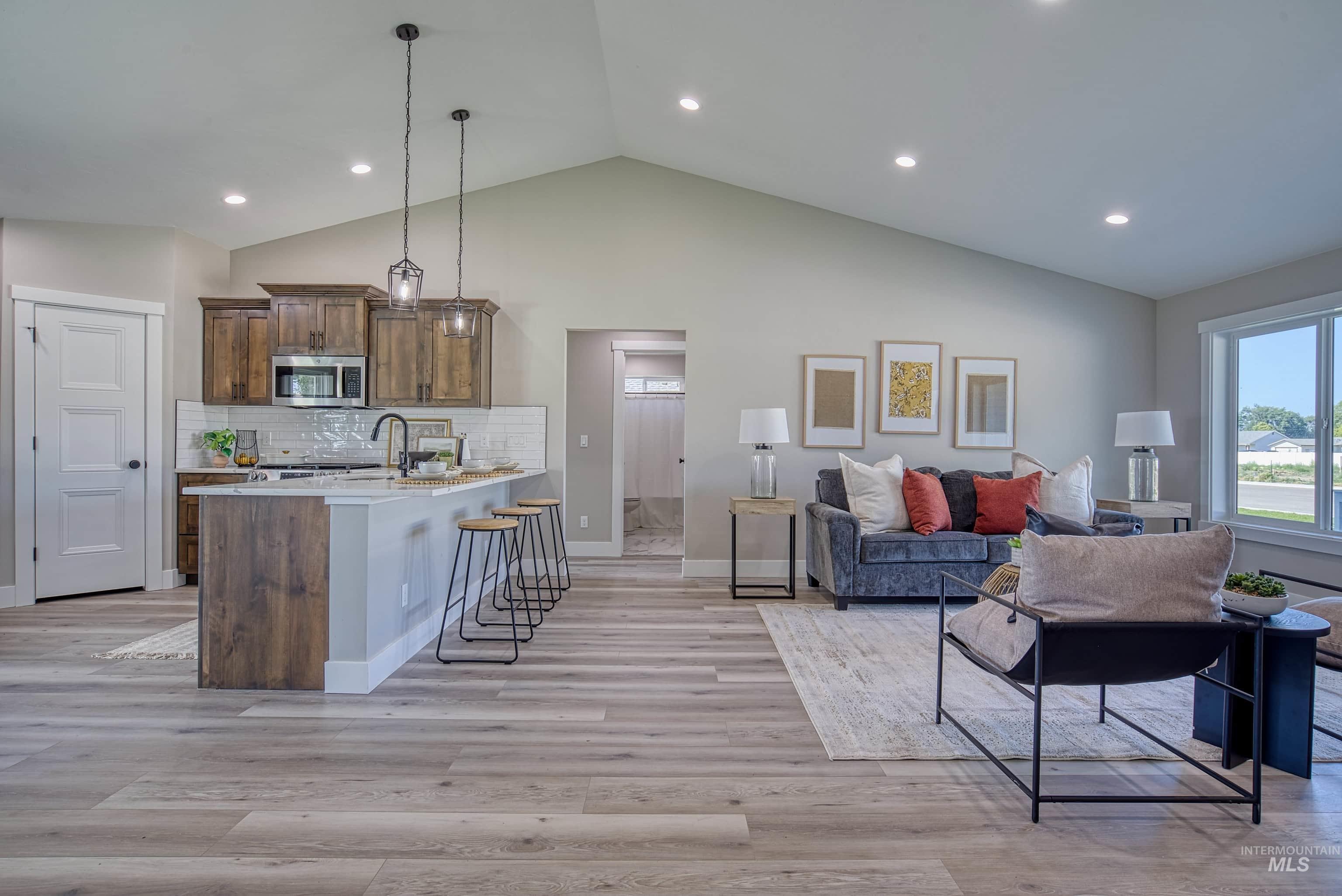 960 Campbell Street Vale, OR 97918 - Photo 4 of 49 Open-concept living area featuring a vaulted ceiling and wood-finish flooring