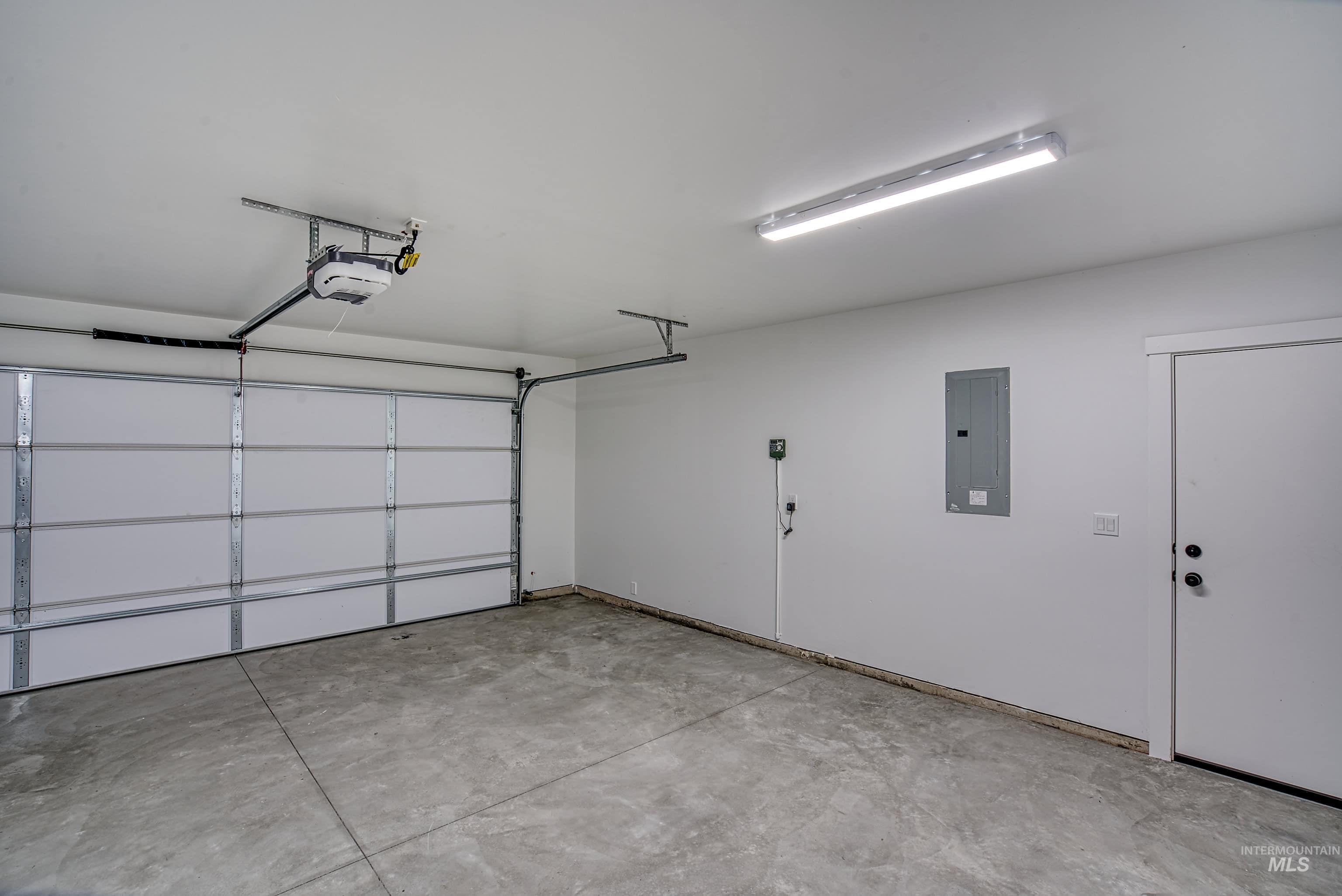 960 Campbell Street Vale, OR 97918 - Photo 43 of 49 Attached single-car garage featuring a concrete floor, automatic garage door opener, and a side entry door