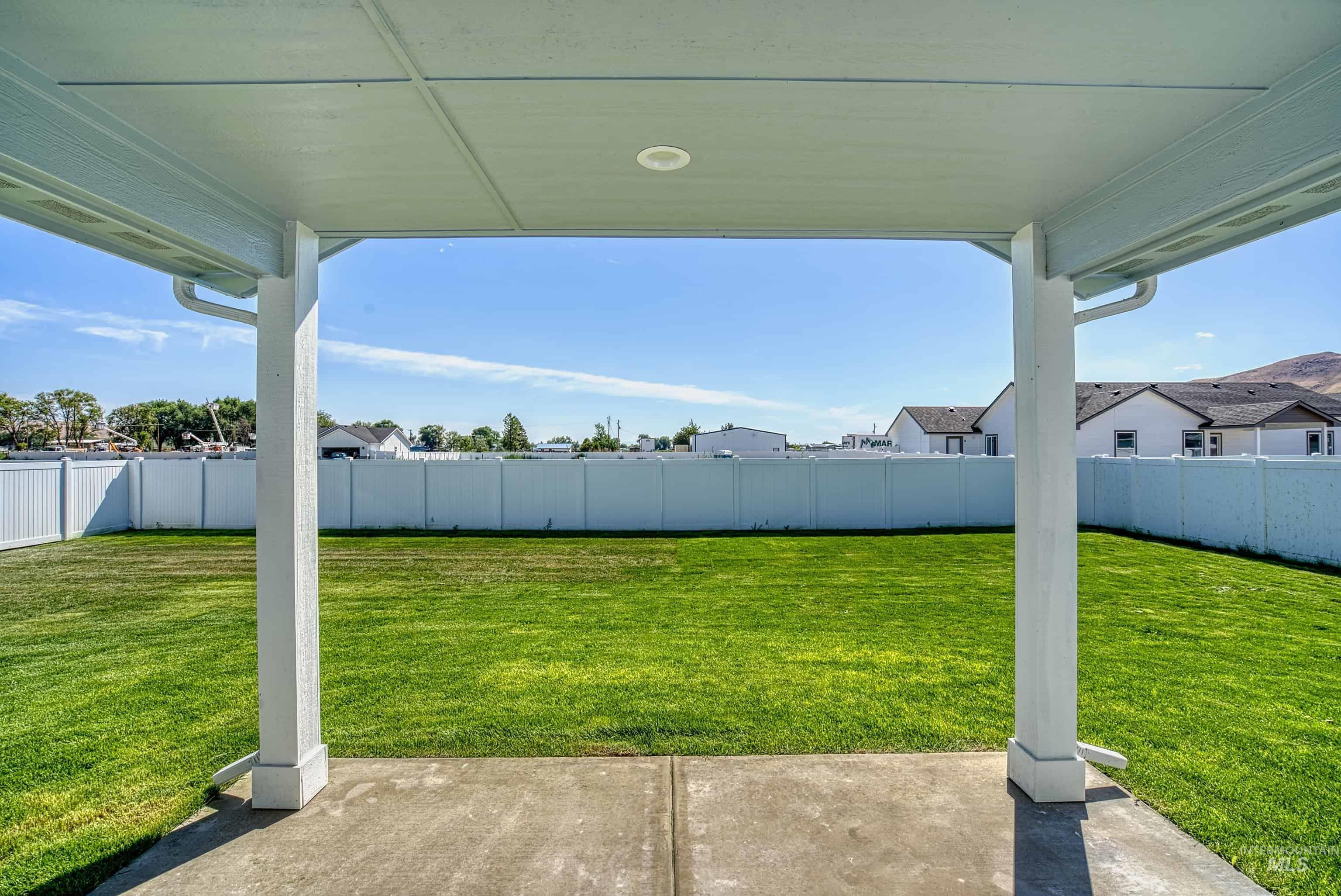 960 Campbell Street Vale, OR 97918 - Photo 47 of 49 Covered patio with a concrete slab, recessed lighting, and a white vinyl privacy fence enclosing a manicured lawn