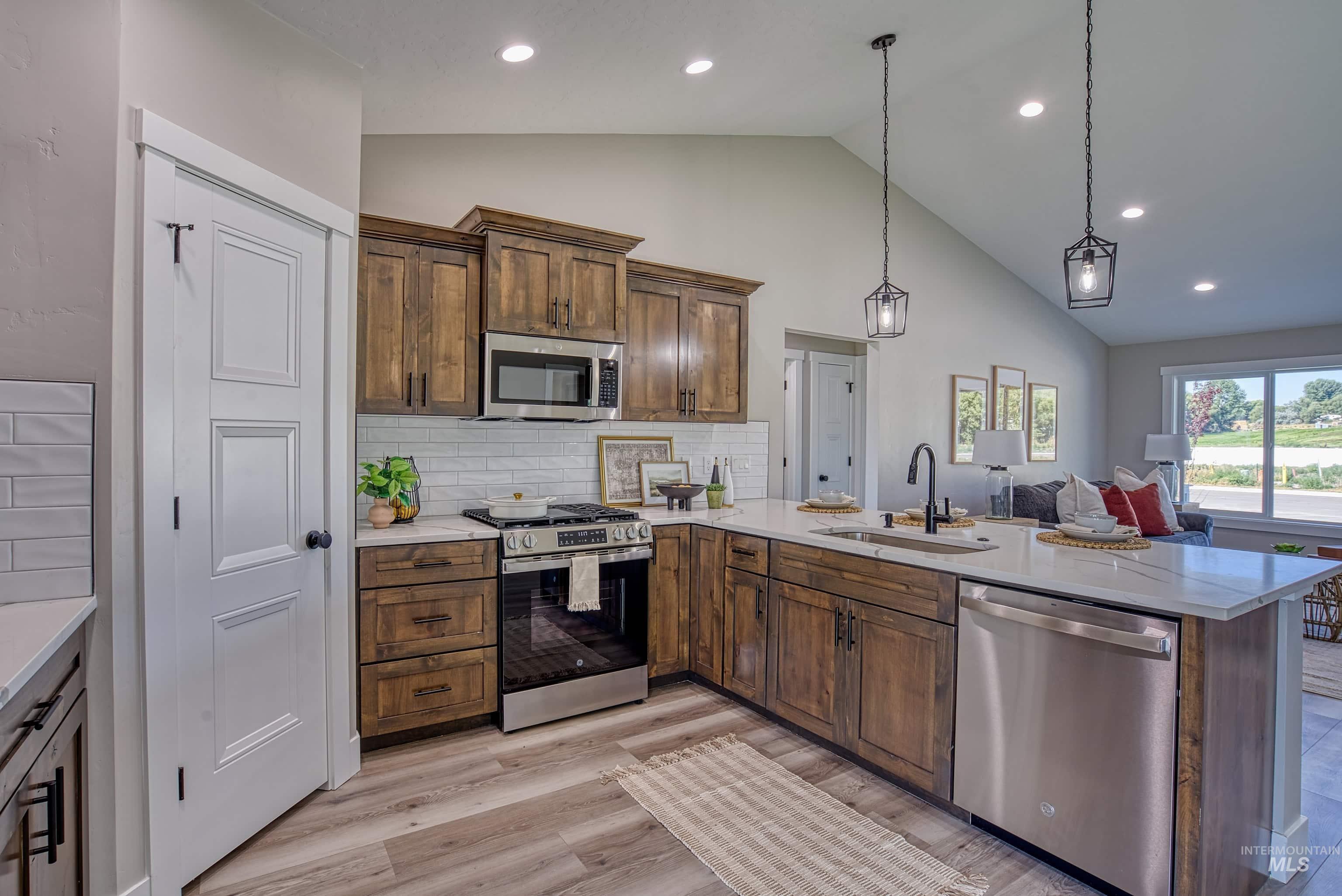 960 Campbell Street Vale, OR 97918 - Photo 9 of 49 Modern kitchen featuring wood-finish cabinetry, white subway tile backsplash, and stainless steel appliances