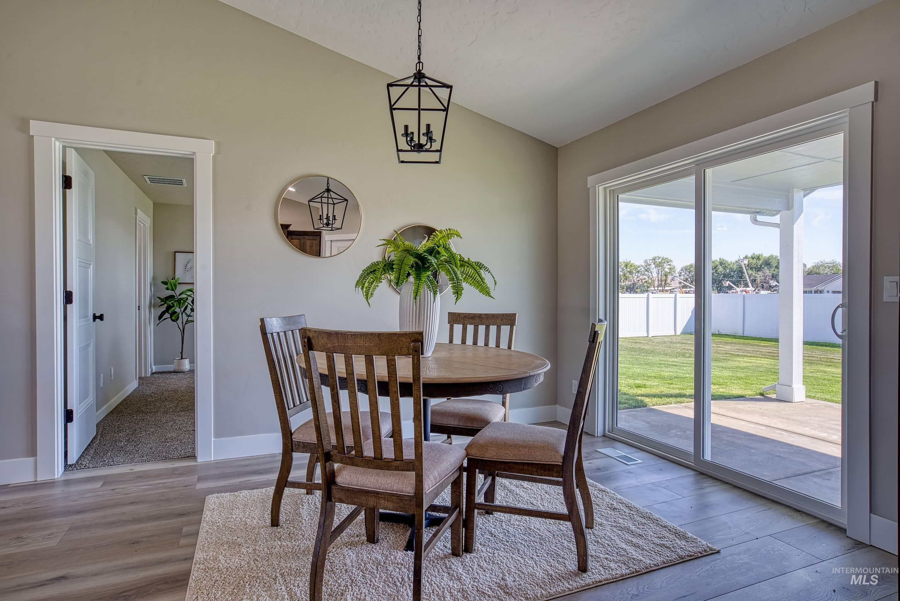 960 Campbell Street Vale, OR 97918 - Photo 10 of 49 Dining area featuring wood-finish flooring and a vaulted ceiling with a hanging light fixture