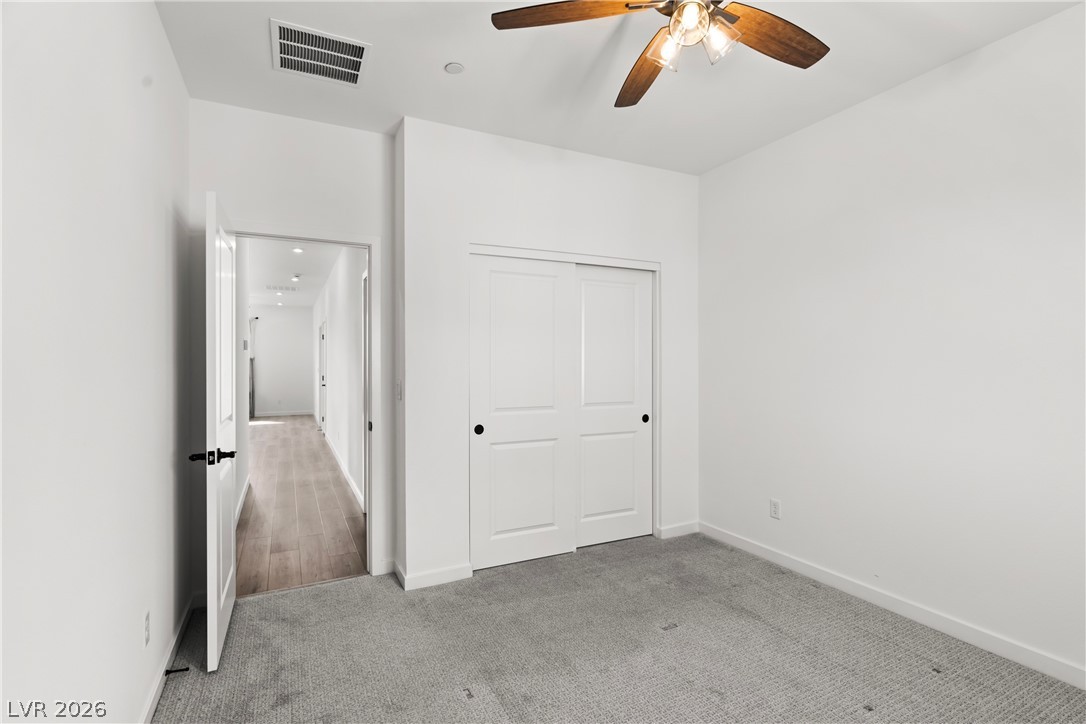 633 Infinity Rdg Street Las Vegas, NV 89138 - Photo 20 of 30 Unfurnished bedroom with light carpet, a closet, and ceiling fan