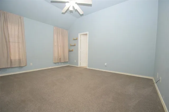 an empty room with a chandelier fan
