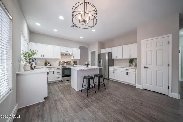 a open kitchen with white cabinets and stainless steel appliances