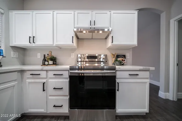 a kitchen with granite countertop white cabinets and white appliances