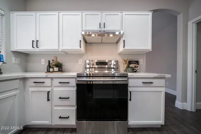 a kitchen with granite countertop white cabinets and white appliances