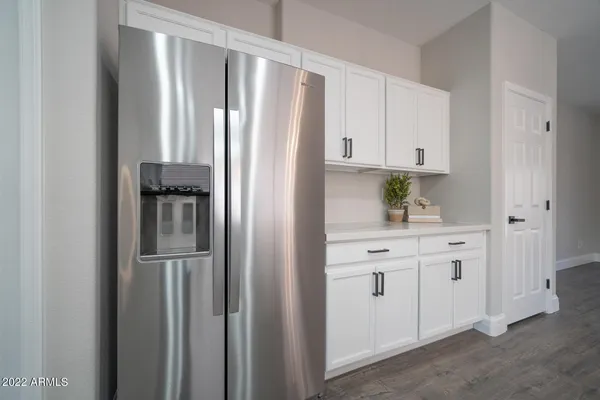 a kitchen with white cabinets and refrigerator