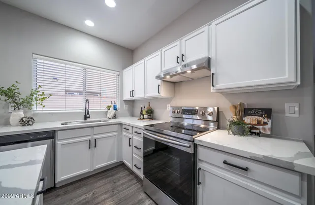 a kitchen with stainless steel appliances a sink a stove and cabinets