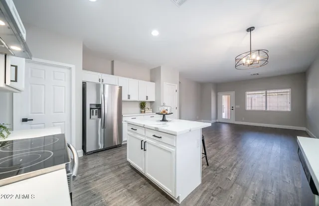 a view of a livingroom with furniture wooden floor and a kitchen