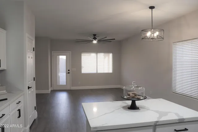 a view of a room with wooden floor chandelier windows and wooden floor