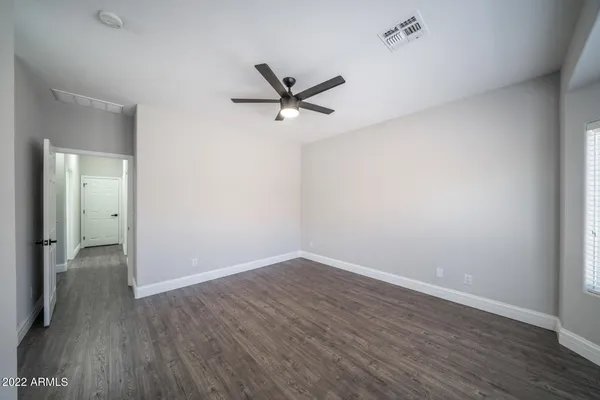 a room with white cabinets and wooden floor