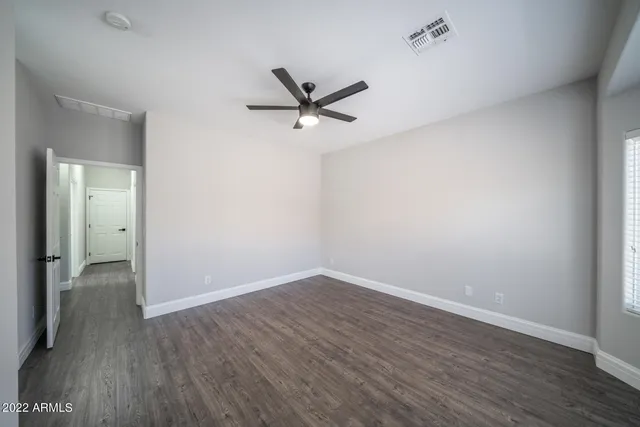 a room with white cabinets and wooden floor