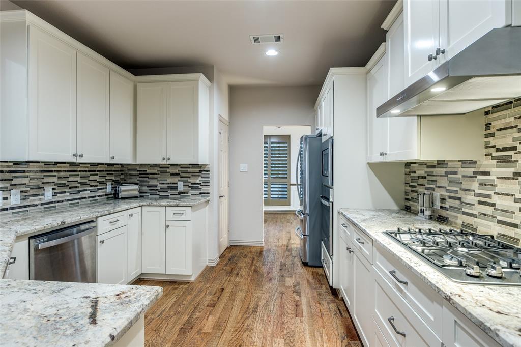 1445 Stagecoach Way Frisco, TX 75033 - Photo 16 of 39 a kitchen with a stove and white cabinets