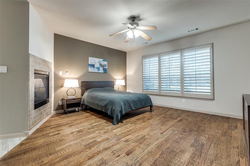 1445 Stagecoach Way Frisco, TX 75033 - Photo 23 of 39 a spacious bedroom with a large bed a chandelier and windows