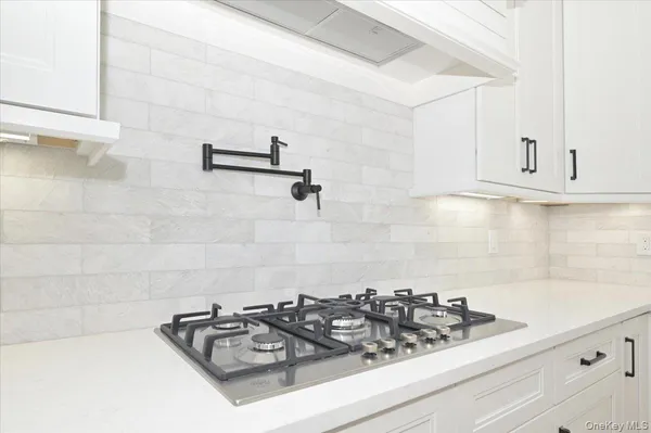 a kitchen with a stove a sink and cabinets