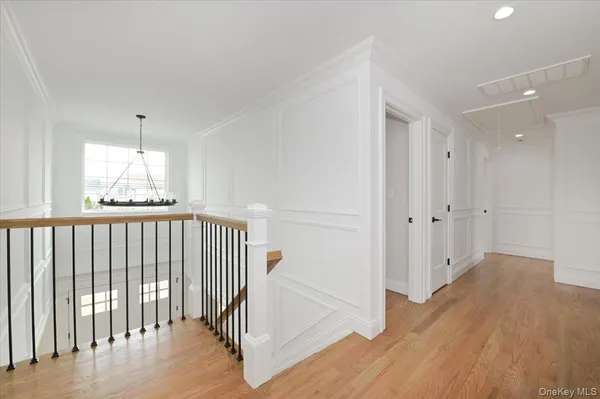 a view of a hallway with wooden floor and windows