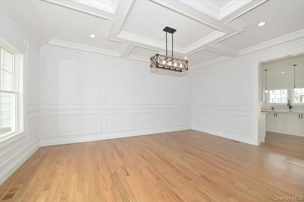 a view of empty room with wooden floor and window