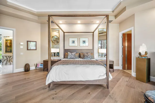 a bedroom with a bed and large window with balcony view