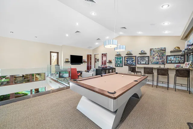 a living room with stainless steel appliances furniture a rug and a flat screen tv