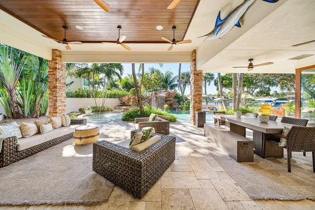 a view of a patio with table and chairs potted plants and large tree