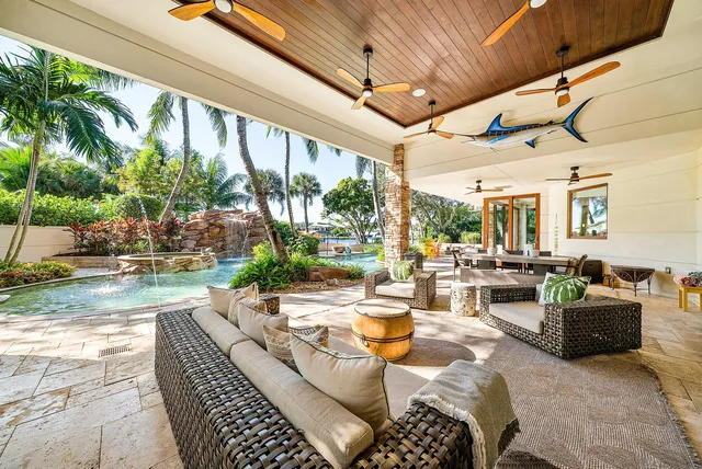 a view of a white house with a big yard and potted plants