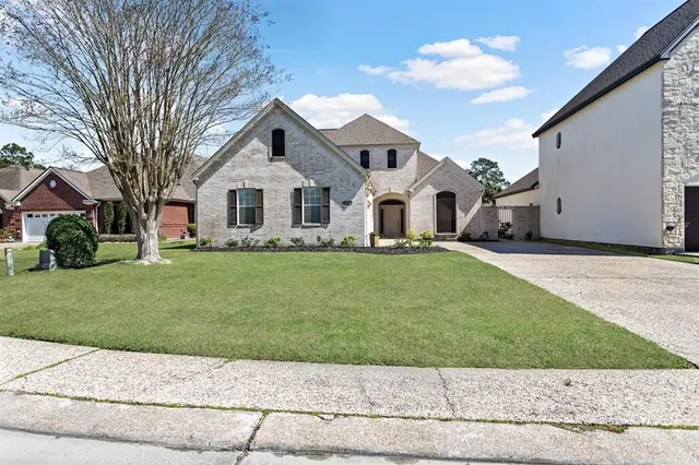 a front view of a house with a garden and trees