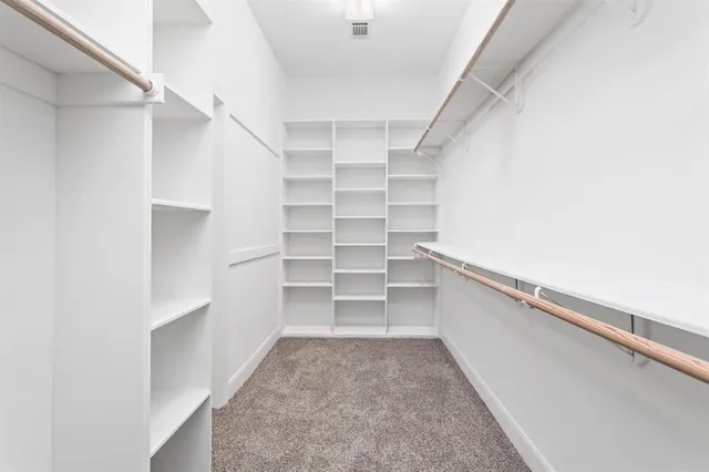 a view of walk in closet with empty racks