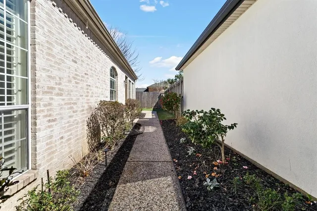 a view of a pathway with flower plants