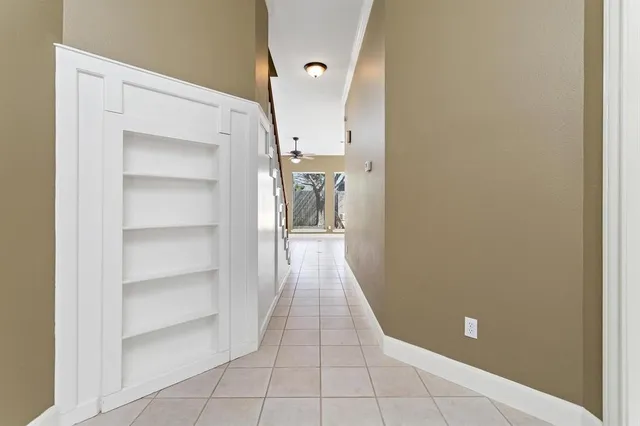 a view of a hallway with wooden shelves