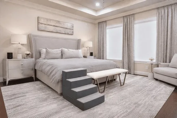 a bedroom with a bed a couch and next to a window