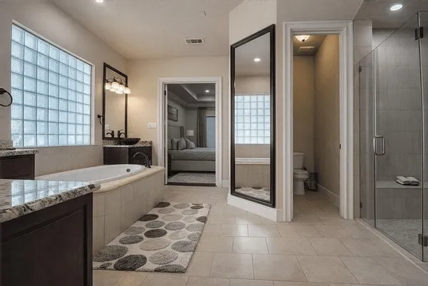 a large bathroom with a granite countertop sink a toilet and shower