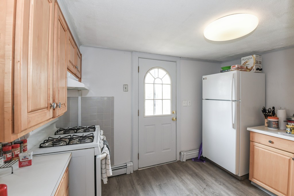 34 Clinton Street Waltham, MA 02453 - Photo 15 of 20 a kitchen with a refrigerator a stove and wooden floor