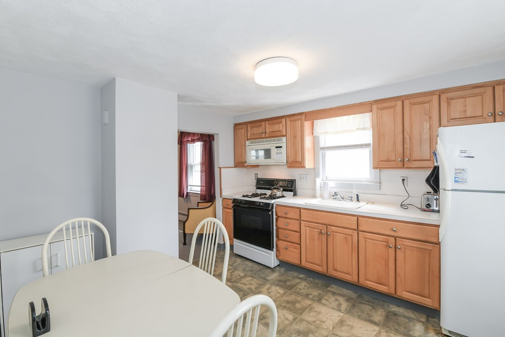 34 Clinton Street Waltham, MA 02453 - Photo 3 of 20 a kitchen with sink a stove and white cabinets