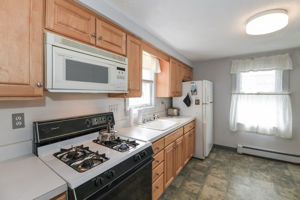 34 Clinton Street Waltham, MA 02453 - Photo 4 of 20 a kitchen with stainless steel appliances granite countertop a stove a sink and a refrigerator