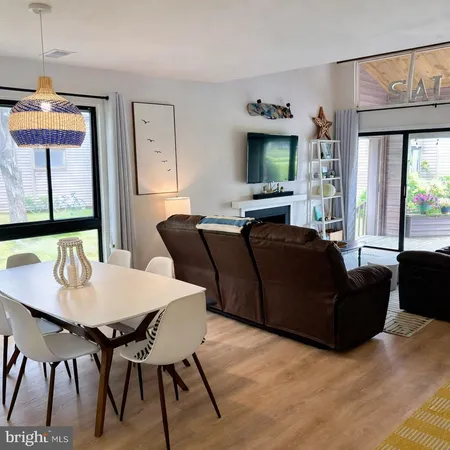 a living room with furniture a flat screen tv and a large window