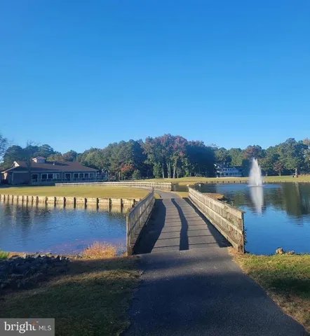 a view of swimming pool with lake and houses in the back