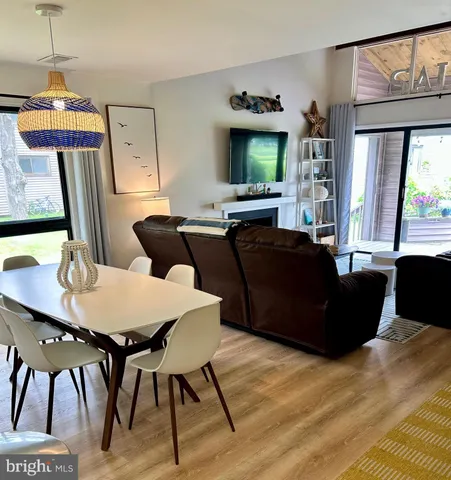 a living room with furniture a flat screen tv and a dining table