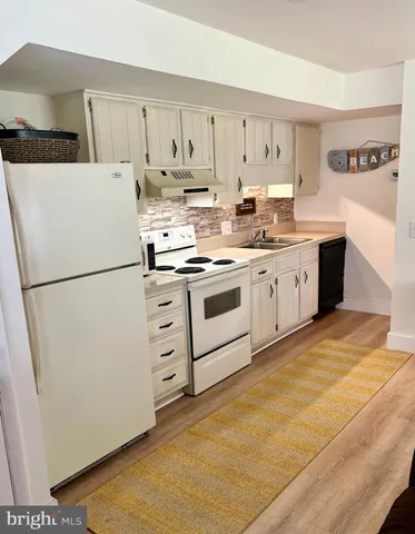 a kitchen with granite countertop cabinets and white appliances
