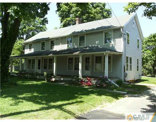a front view of a house with a yard and potted plants