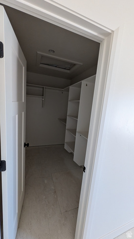 26063 North 8800th West Portage, UT 84331 - Photo 5 of 9 Walk-in closet featuring built-in shelving, hanging rods, and light-toned tile flooring