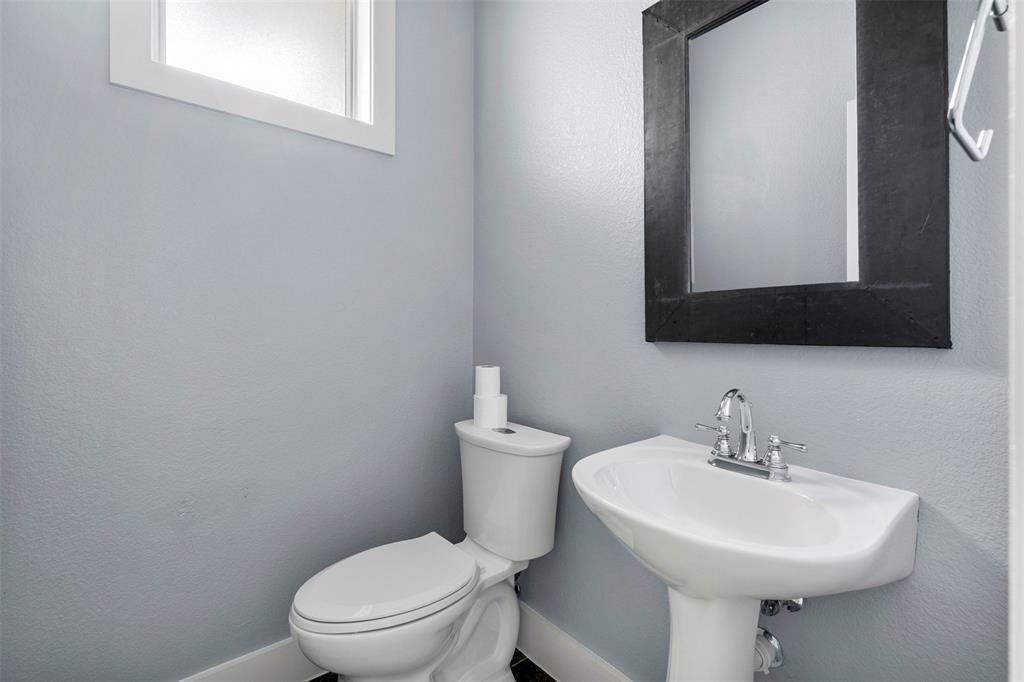 4830 Cedar Springs Road, Unit 30 Dallas, TX 75219 - Photo 23 of 32 a bathroom with a toilet a sink and mirror