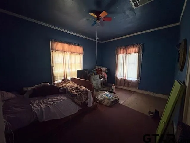 a bed sitting in a bedroom next to a window