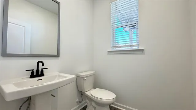 a bathroom with a toilet a sink and mirror
