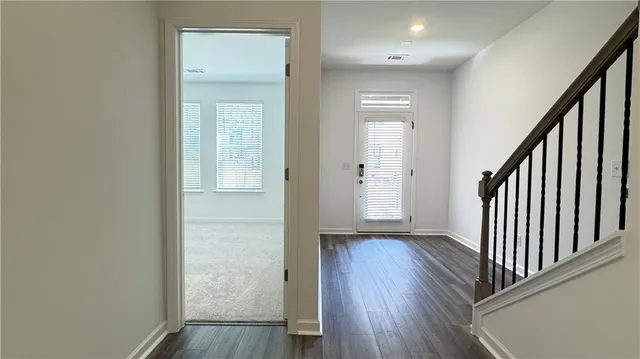 a view of a hallway with wooden floor and staircase