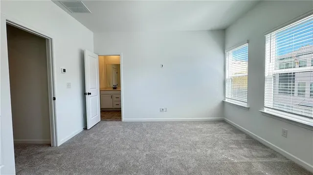 an empty room with windows and closet