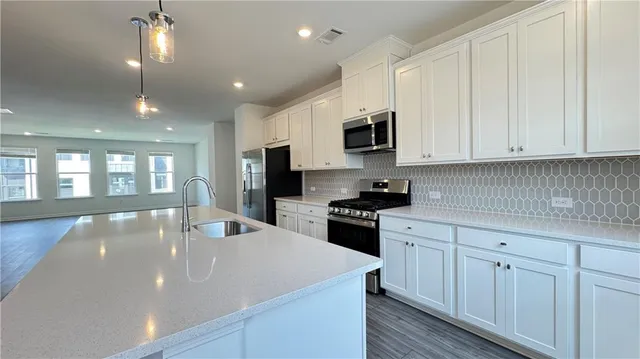 a kitchen with sink a microwave and cabinets