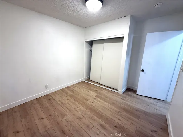 an empty room with wooden floor and mirror