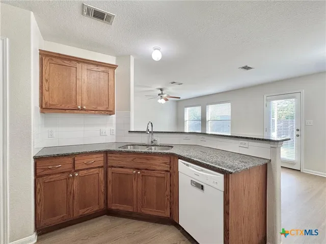 a kitchen with sink stove and cabinets