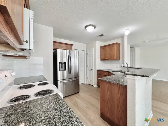 a kitchen with a refrigerator and a sink