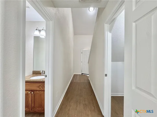 a view of a hallway with wooden floor and closet